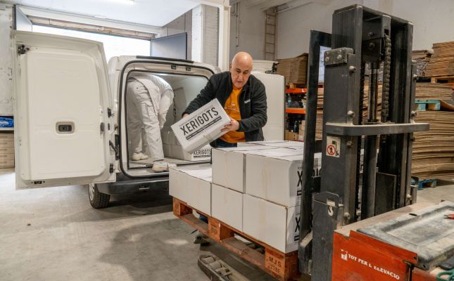 Representants de Xerigots i del Rebost Solidari amb les caixes que contenen la donació